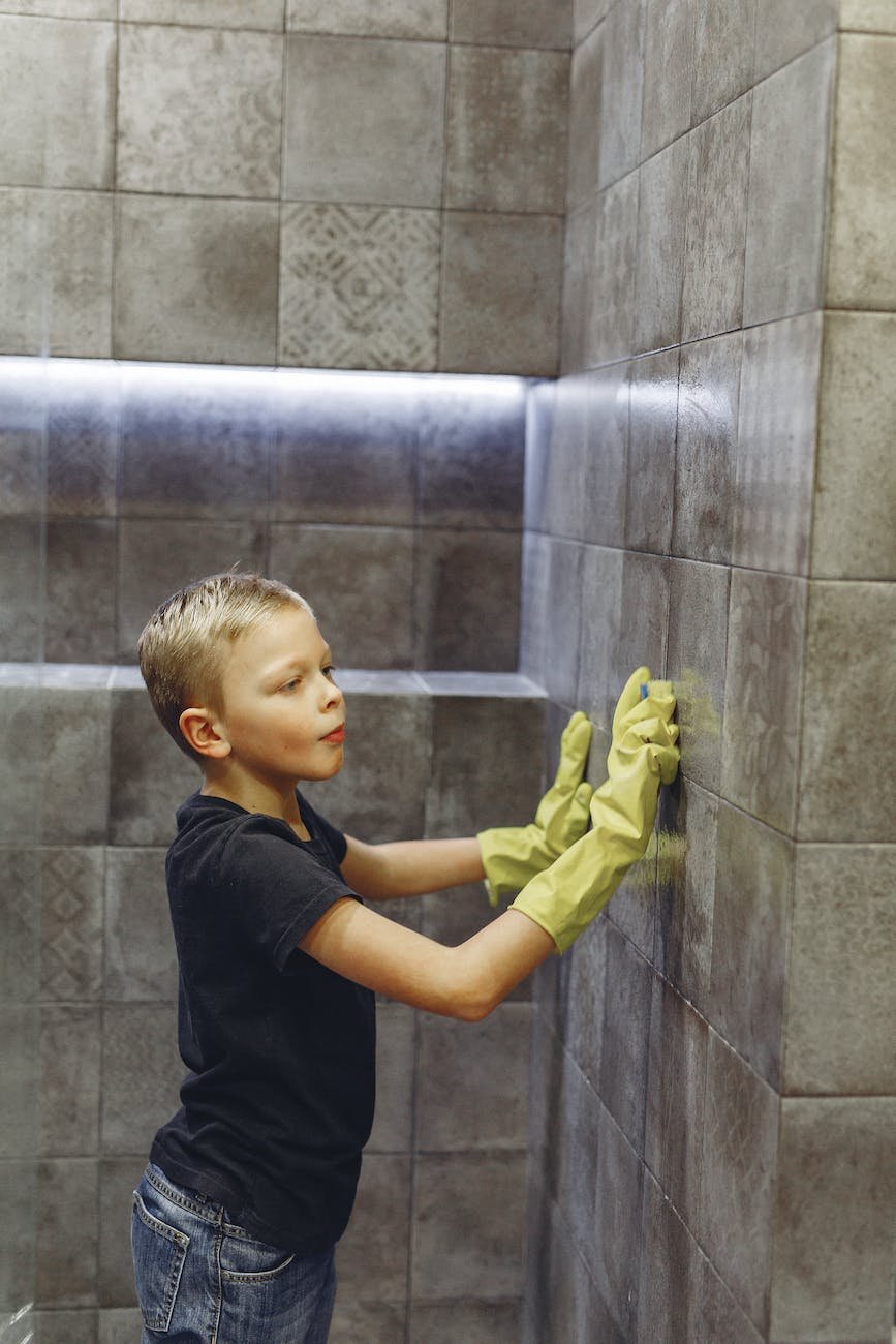small boy cleaning tiles in bathroom