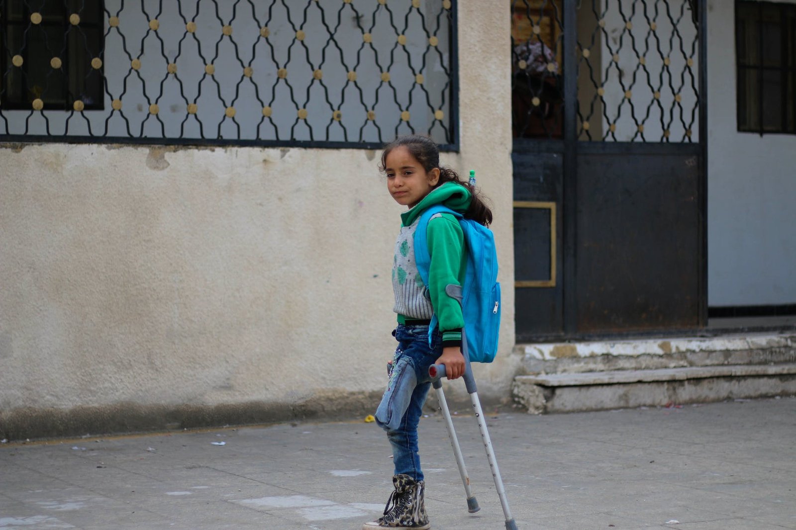 ethnic amputated girl walking on crutches