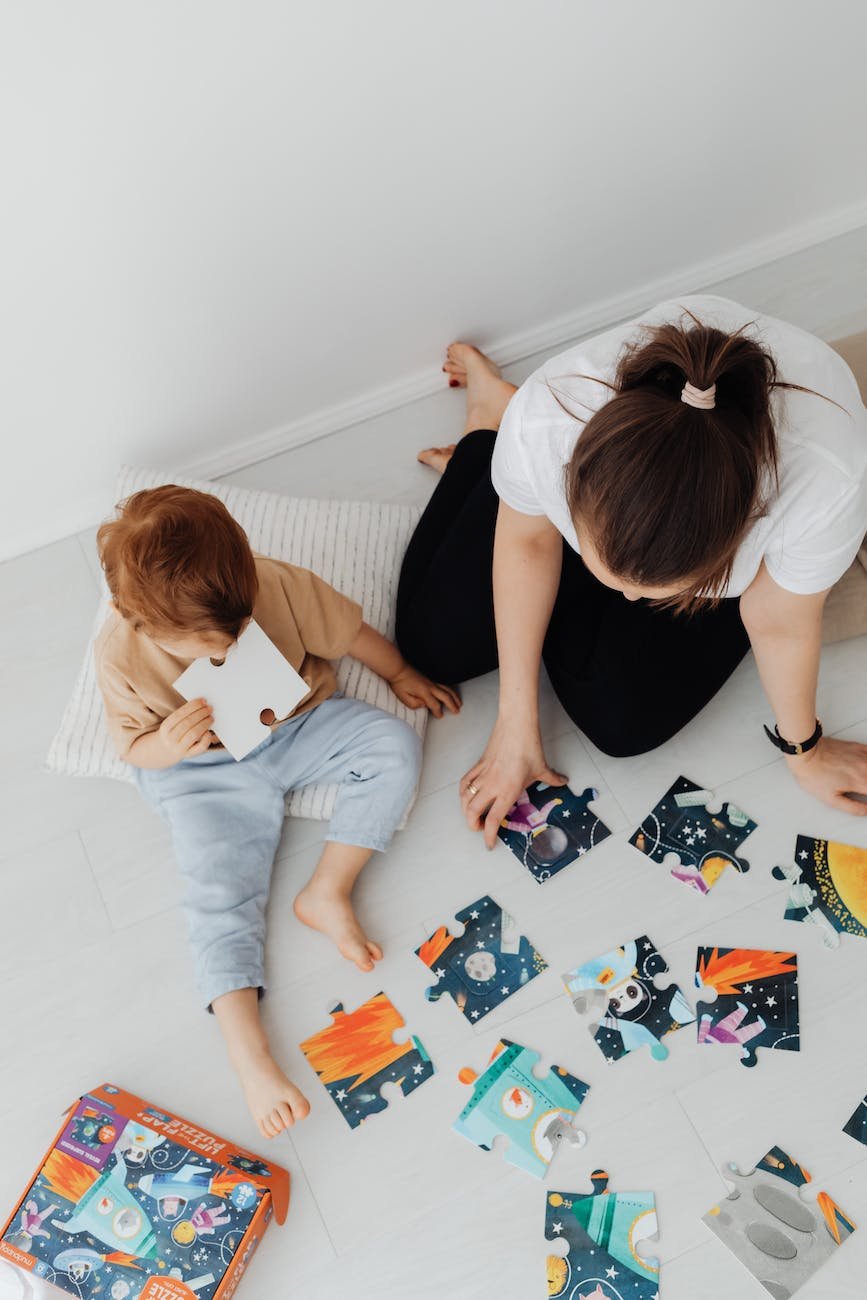 a woman and a young boy playing puzzles