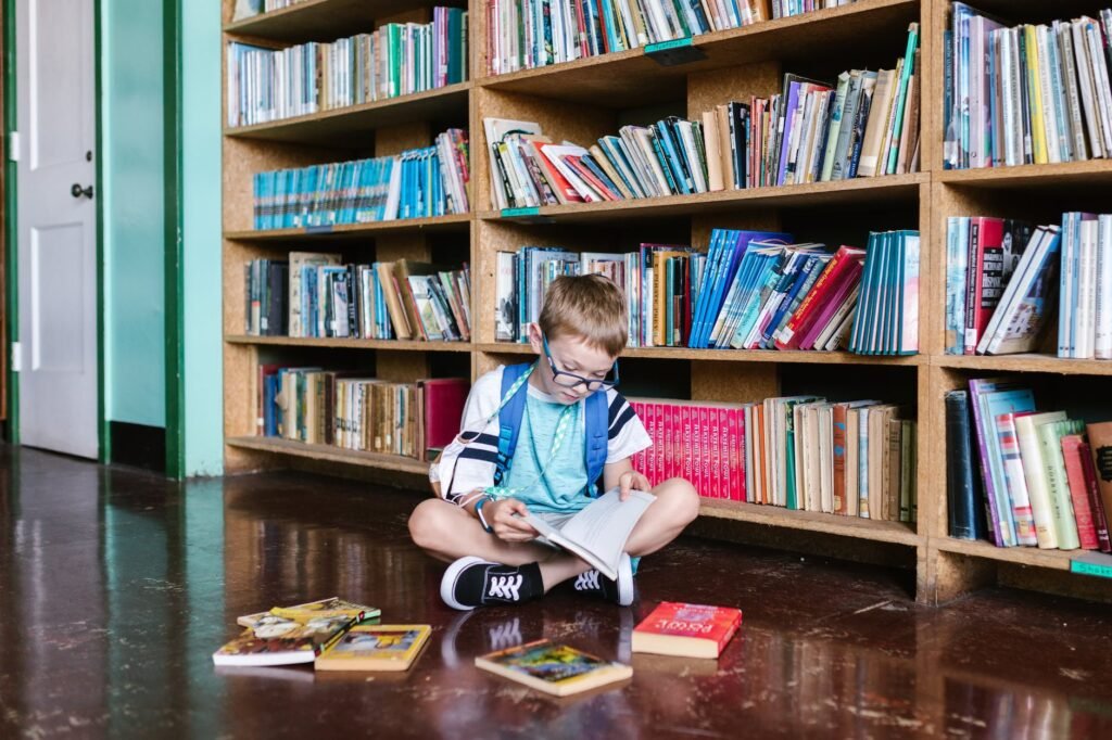 boy sitting on floor reading a book